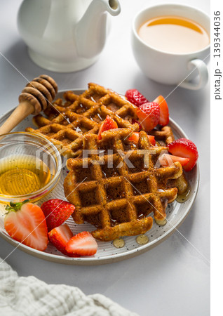 Belgian waffles with strawberries, cup of tea and fresh fruits. Homemade breakfast food Belgian waffles with strawberries, cup of tea and fresh fruits. Homemade breakfast food 139344036