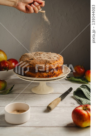 Homemade apple cake with cinnamon on cake stand, lifestyle moody food photo Homemade apple cake with cinnamon on cake stand, lifestyle moody food photo 139344083