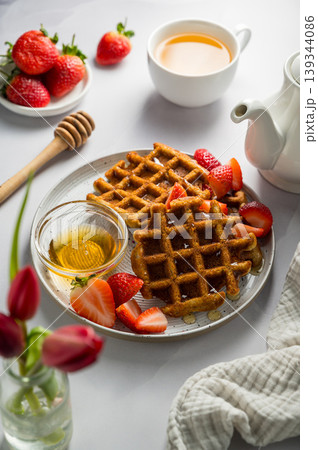 Belgian waffles with strawberries, cup of tea and fresh fruits. Homemade breakfast food Belgian waffles with strawberries, cup of tea and fresh fruits. Homemade breakfast food 139344086