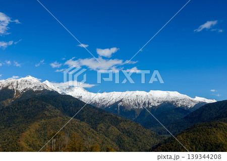 Mountains covered in snow stand under a clear blue sky in the daytime 139344208
