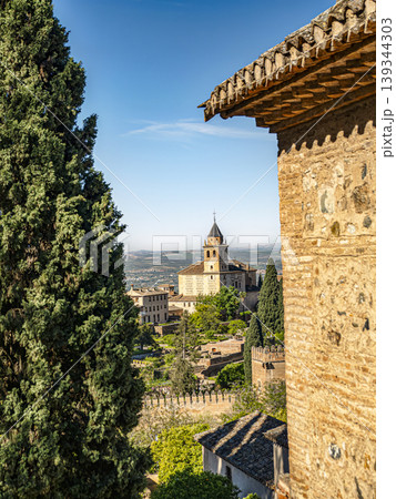 Alhambra Tower and Gardens Framed by Cypress Trees and Stone Walls in Granada, Spain 139344303