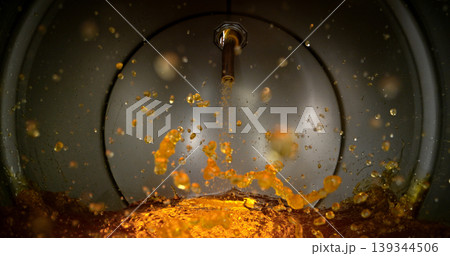 Gasoline jet pouring into metal fuel tank, inside view with dynamic splash and turbulence. Concept of refueling, fuel storage and energy supply, industrial environment. Gasoline jet pouring into metal fuel tank, inside view with dynamic splash and turbulence. Concept of refueling, fuel storage and energy supply, industrial environment. 139344506
