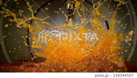 Gasoline jet pouring into metal fuel tank, inside view with dynamic splash and turbulence. Concept of refueling, fuel storage and energy supply, industrial environment. Gasoline jet pouring into metal fuel tank, inside view with dynamic splash and turbulence. Concept of refueling, fuel storage and energy supply, industrial environment. 139344507