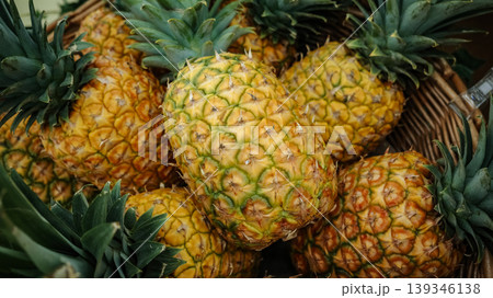 Fresh ripe pineapples with green crowns at market Fresh ripe pineapples with green crowns at market 139346138