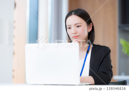 パソコンの前で真剣な表情で考える悩むデスクワーク業務に取り組む女性会社員　困ったな～ 139346816