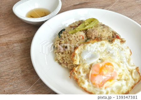 spicy fried mixed rice with chop pork basil topping egg in plate dipping chili fish sauce  139347381