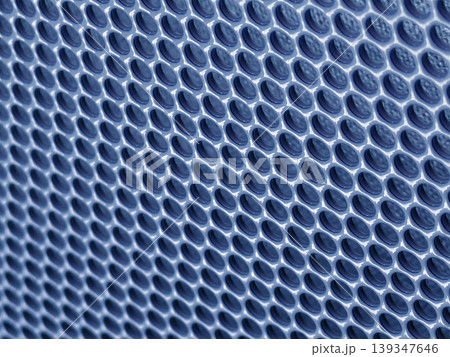Close-up of shiny perforated metal surface with blurred background and patterned holes Close-up of shiny perforated metal surface with blurred background and patterned holes 139347646
