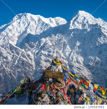 Prayer flags with beautiful view of Mt.Annapurna South (7,219 m) and Mt.Hiunchuli (6,441 m) seen from Mardi Himal view point in the Annapurna region of Nepal. Prayer flags with beautiful view of Mt.Annapurna South (7,219 m) and Mt.Hiunchuli (6,441 m) seen from Mardi Himal view point in the Annapurna region of Nepal. 139347881