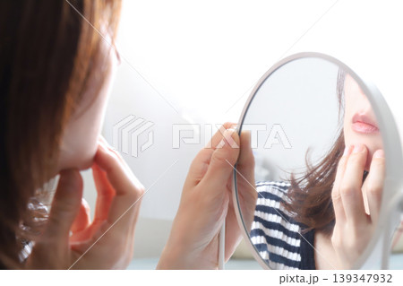 鏡で肌を確認する女性 139347932