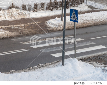 Crosswalk on snowy street in winter showing pedestrian sign and fresh snow in the area around Crosswalk on snowy street in winter showing pedestrian sign and fresh snow in the area around 139347970