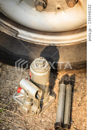 Pneumatic car jack next to old tire Pneumatic car jack next to old tire 139348182