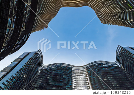 Curved modern skyscrapers forming abstract frame against blue sky 139348216