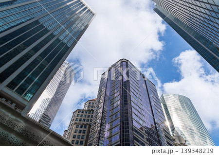 Glass skyscrapers viewed from below against blue sky Glass skyscrapers viewed from below against blue sky 139348219