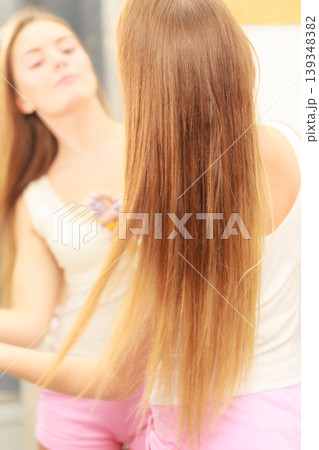 Woman taking care of her long hair applying cosmetic oil 139348382