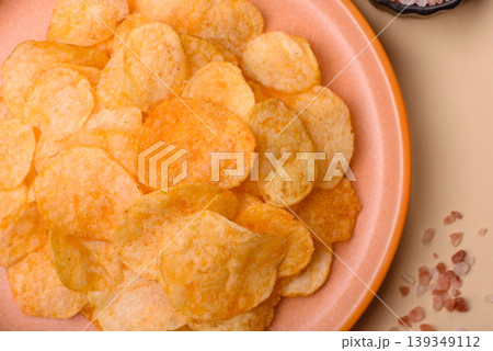 Crispy potato chips, golden slices seasoned with salt and spices. Potato chips Crispy potato chips, golden slices seasoned with salt and spices. Potato chips 139349112