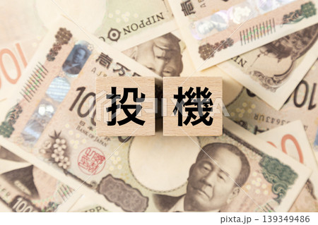 「投機」と書かれたブロックとたくさんの一万円札 「投機」と書かれたブロックとたくさんの一万円札 139349486