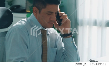 Skilled engineer look at mobile phone while working on tablet. Alimentation. Skilled engineer look at mobile phone while working on tablet. Alimentation. 139349555