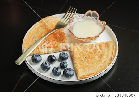 Pancakes with blueberry and honey on a white plate 139349907