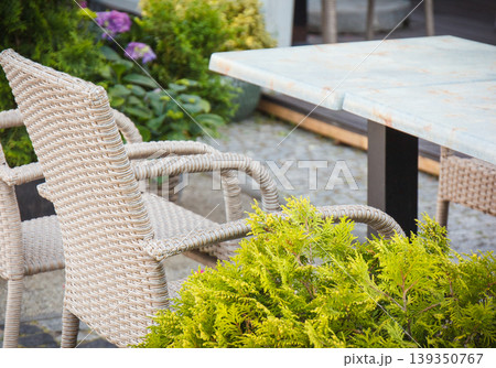 Chairs made of wicker or rattan and tables on restaurant terrace. Relaxation time on fresh air 139350767