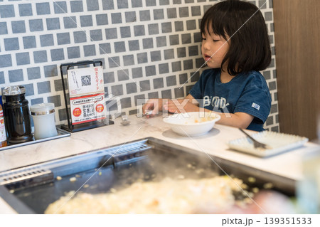 鉄板焼き店でもんじゃ焼きを食べる日本人の女の子の幼児 139351533