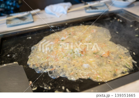 鉄板の上で焼かれる海鮮もんじゃ焼き 鉄板の上で焼かれる海鮮もんじゃ焼き 139351665
