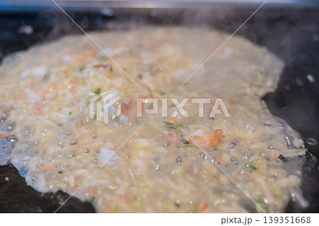 鉄板の上で焼かれる海鮮もんじゃ焼き 鉄板の上で焼かれる海鮮もんじゃ焼き 139351668