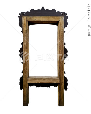 A handmade wooden mirror frame featuring an ornate top and open space for personal artwork. The frame stands isolated, allowing for diverse creative ideas. A handmade wooden mirror frame featuring an ornate top and open space for personal artwork. The frame stands isolated, allowing for diverse creative ideas. 139351717