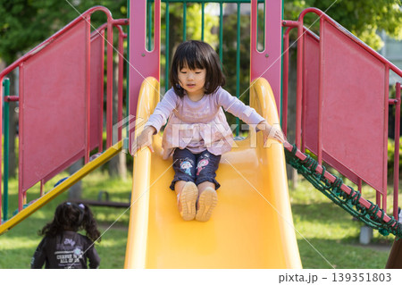 公園の滑り台を滑り降りる日本人の女の子の幼児 公園の滑り台を滑り降りる日本人の女の子の幼児 139351803