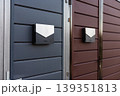 Modern mailboxes mounted on contrasting colored gates for secure deliveries 139351813