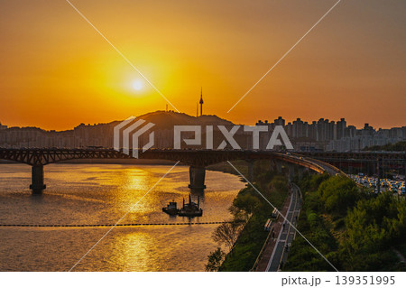 Seoul, South Korea - Apr. 24, 2026 : Beautiful golden hour over the busy urban highway with cars and city skyline Seoul, South Korea - Apr. 24, 2026 : Beautiful golden hour over the busy urban highway with cars and city skyline 139351995