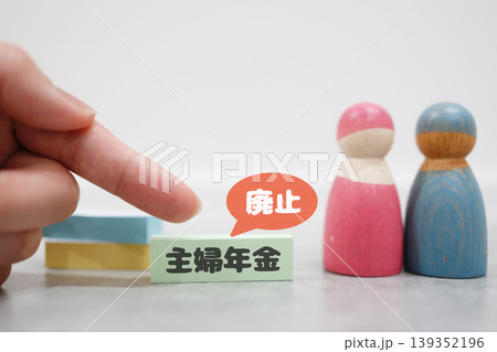 主婦年金廃止のイメージ。夫婦の木製人形と付箋で表現した社会保障の課題 主婦年金廃止のイメージ。夫婦の木製人形と付箋で表現した社会保障の課題 139352196