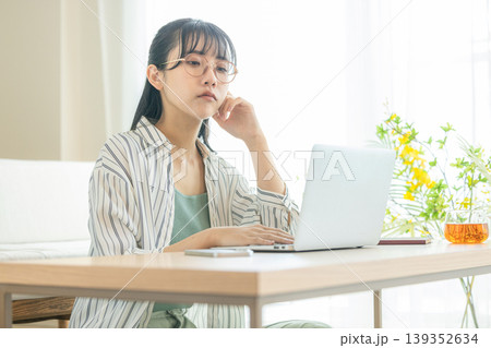 パソコンを見ながら考え込む若い女性 パソコンを見ながら考え込む若い女性 139352634