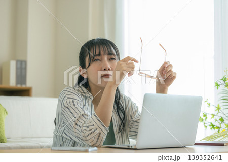 眼精疲労で眼鏡を外して休息する女性 眼精疲労で眼鏡を外して休息する女性 139352641