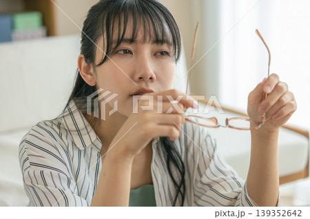 眼精疲労で眼鏡を外して休息する女性 眼精疲労で眼鏡を外して休息する女性 139352642