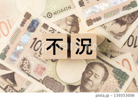 「不況」と書かれたブロックとたくさんの一万円札 「不況」と書かれたブロックとたくさんの一万円札 139353006