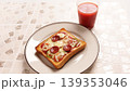 焼きたてのピザトーストと冷たいトマトジュースのある食卓 139353046
