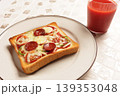 焼きたてのピザトーストと冷たいトマトジュースのある食卓 139353048