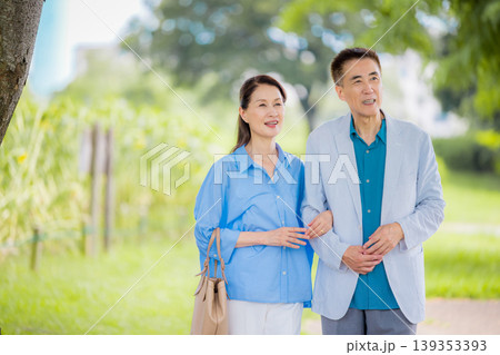 屋外で手を組んで歩くシニア夫婦 屋外で手を組んで歩くシニア夫婦 139353393