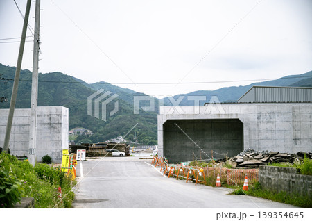 東日本大震災の津波対策で新築された防潮堤の開口部と工事現場 東日本大震災の津波対策で新築された防潮堤の開口部と工事現場 139354645