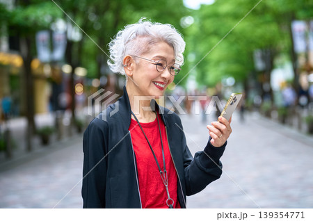 スマホ画面を見て笑顔のシニア女性 スマホ画面を見て笑顔のシニア女性 139354771