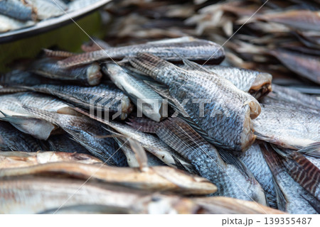 Fresh fish stacked at market showing natural texture and scales highlighting seafood supply freshness and traditional fishery trade environment Fresh fish stacked at market showing natural texture and scales highlighting seafood supply freshness and traditional fishery trade environment 139355487