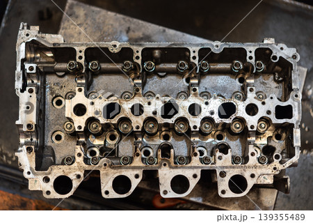 Close view of engine cylinder head with valves and ports showing mechanical components maintenance repair and automotive engineering workshop process Close view of engine cylinder head with valves and ports showing mechanical components maintenance repair and automotive engineering workshop process 139355489