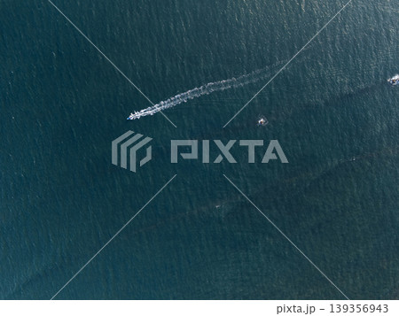 Boat moves across water in sunny weather at a coastal location Boat moves across water in sunny weather at a coastal location 139356943