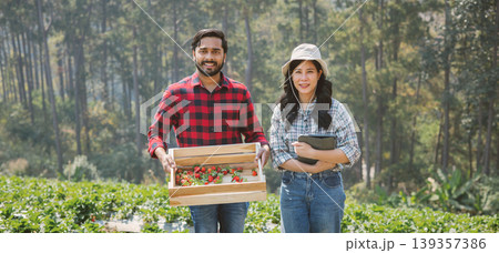 Two farmers stand in a vibrant green field 139357386