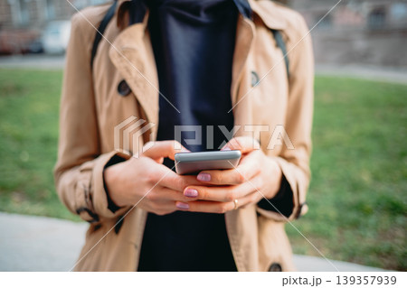 Close-up of woman using mobile phone while walking outside 139357939