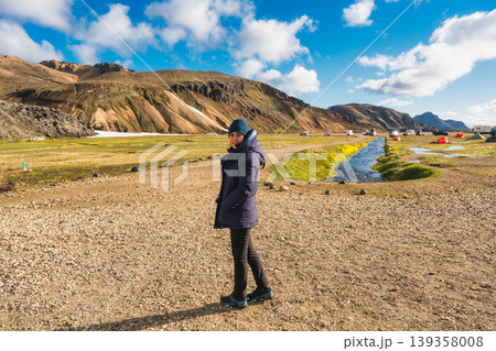Female traveler among volcanic mountain near campsite at Landmannalaugar, Icelandic Highlands Female traveler among volcanic mountain near campsite at Landmannalaugar, Icelandic Highlands 139358008