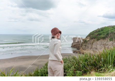 Asian woman enjoying on coastline near Muriwai Gannet Colony in New Zealand 139358055