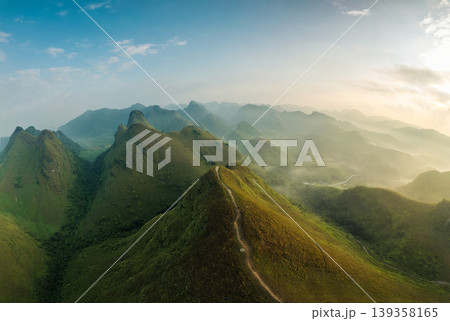 Scenery of Ba Guang grass hill, Mountain range with fog and villager bringing horse to graze on the mountain in the morning 139358165