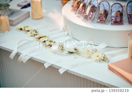 White floral ribbon with purfume, candle on event table in celebration or reception event 139358219