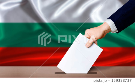 Bulgaria Parliamentary vote. Hand placing a ballot in ballot box with the Bulgarian flag in the background Bulgaria Parliamentary vote. Hand placing a ballot in ballot box with the Bulgarian flag in the background 139358737